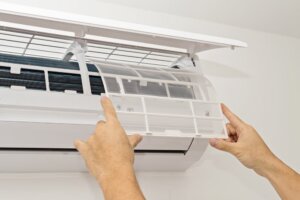 person replacing their air conditioner filter