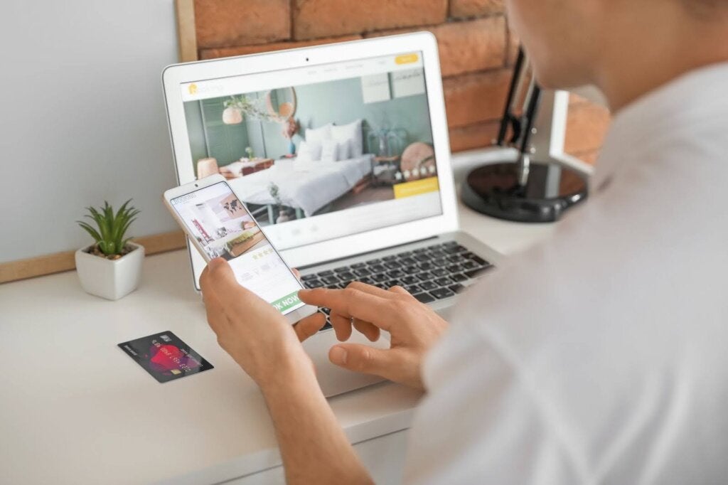 Phone in hand and view of laptop screen 